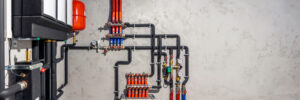 Heizungssysteme mit Rohren, Pumpen und Verteilerkästen an der Wand, die warmes Wasser im Haus verteilen