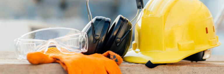 Sicherheitshelm, Kopfhörer und Handschuhe - Sicherheit auf der Baustelle